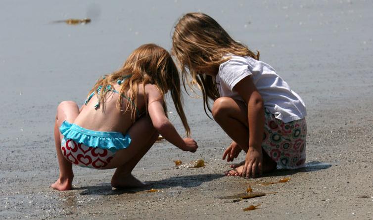 Two girls playing in the sand on the beach