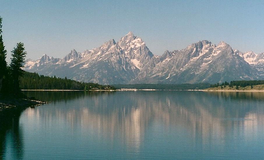 Snow-capped mountains behind a still blue lake